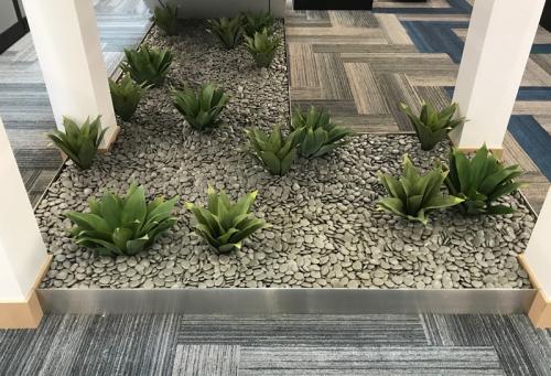 Because of the location and low light, we used replica Agaves and decorative stones in this space. 